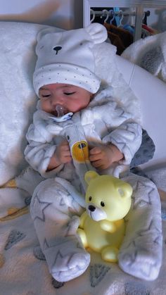 a baby in a bear costume is holding a pacifier