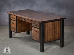 a wooden desk sitting on top of a cement floor next to a gray wall with black metal legs