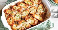 a casserole dish filled with baked potatoes and topped with parmesan cheese