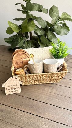 a basket filled with coffee cups sitting on top of a wooden table next to a potted plant