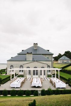 an outdoor dining area with tables and chairs in front of a large building on a cloudy day