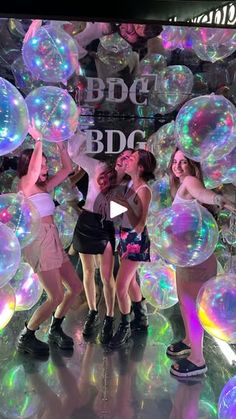 the girls are playing with bubbles on the floor in front of an advertisement for bbg