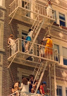 several people are standing on the top of a building