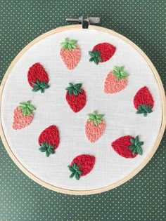 a close up of a cross stitch pattern with strawberries in the middle on a table