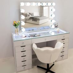 a white chair sitting in front of a vanity with a mirror on top of it