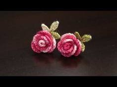 two crocheted roses sitting on top of a table