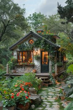 a small house surrounded by greenery and flowers