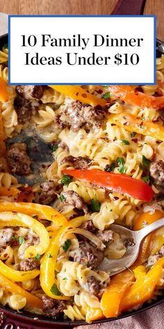 a skillet filled with pasta and vegetables on top of a wooden table