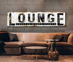 a couch sitting in front of a brick wall with the word lounge painted on it