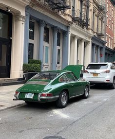 a green car parked on the side of a street