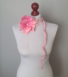 a white mannequin with a pink flower on it's neck and headband