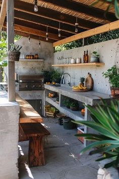 an outdoor kitchen with potted plants on the counter and shelves above it for cooking