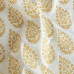 a white and gold fabric with an ornate design on it's surface, close up