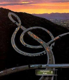 an image of a highway going through the mountains at night with lights in the middle