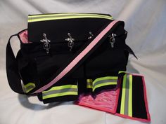 a black bag with neon stripes and pink linings on the bottom is sitting on a white sheet