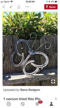 a metal sculpture sitting on top of a wooden bench