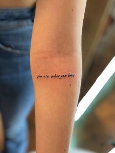 a woman's arm with a tattoo saying you are what you love