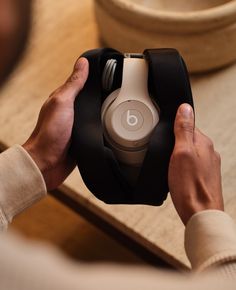 a person holding onto an object with headphones on it's ears and hands