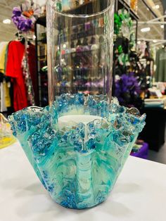 a glass vase sitting on top of a table in front of a store display case