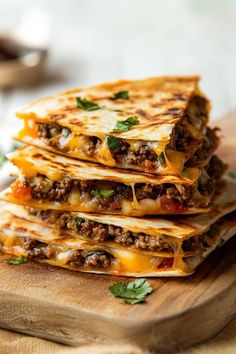 three quesadillas stacked on top of each other with cheese and meat in the middle