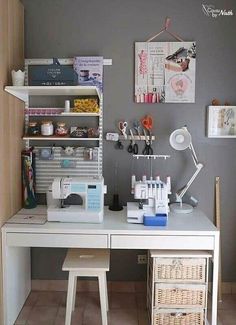 a sewing machine sitting on top of a white desk next to a shelf filled with craft supplies