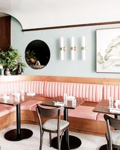 a restaurant with pink booths and black tables