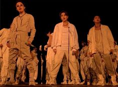 three men in white outfits standing next to each other with their hands on their hips