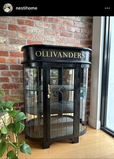 an old fashioned black cabinet sitting in front of a brick wall with the name ollivanders written on it