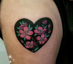 a heart shaped tattoo with pink flowers on it