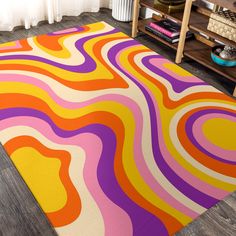 a colorful area rug with an abstract design on the floor in front of a window