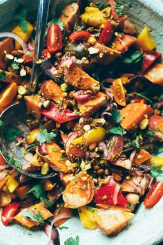 a bowl filled with lots of different types of food and a spoon on top of it