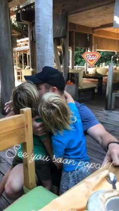 a man and two children hugging each other on a wooden deck with the caption see you soon papa