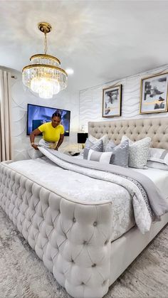 a man standing next to a large bed in a bedroom