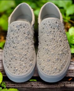 a pair of shoes with silver sequins on them sitting on a wooden bench