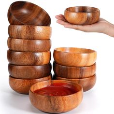 a hand is reaching for some wooden bowls