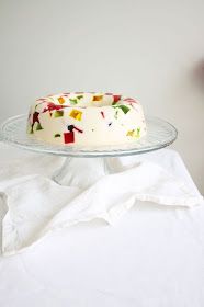 a cake sitting on top of a glass plate next to a white tablecloth and napkin