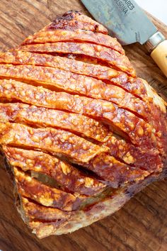 sliced meat sitting on top of a cutting board next to a knife