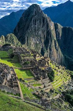 the ruins of machaca picchuta are surrounded by green grass and mountain peaks