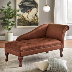 a brown chaise lounger sitting on top of a rug next to a window