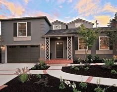 a gray house with two garages and landscaping