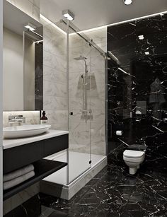 a bathroom with black and white marble walls, flooring and a walk in shower