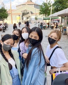 four young women wearing face masks standing together