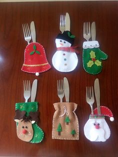 christmas decorations made out of forks and napkins on a wooden table with snowmen