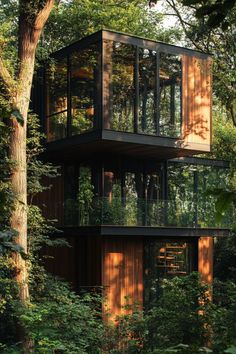 three story house in the woods surrounded by trees and greenery with glass balconies