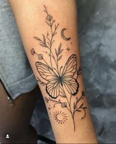 a woman's arm with a butterfly and flowers tattoo on the left side of her leg