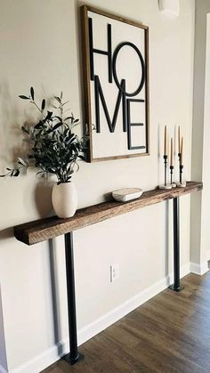 a table with candles and a vase on it in front of a sign that says home