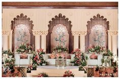 an elaborately decorated stage with flowers and greenery