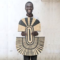 a man is holding a large fan in front of his face and smiling at the camera