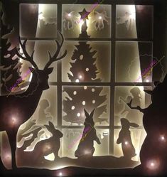 the silhouettes of deer and trees are lit up by lights in front of a window