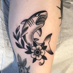 a black and white photo of a shark with flowers on it's leg,